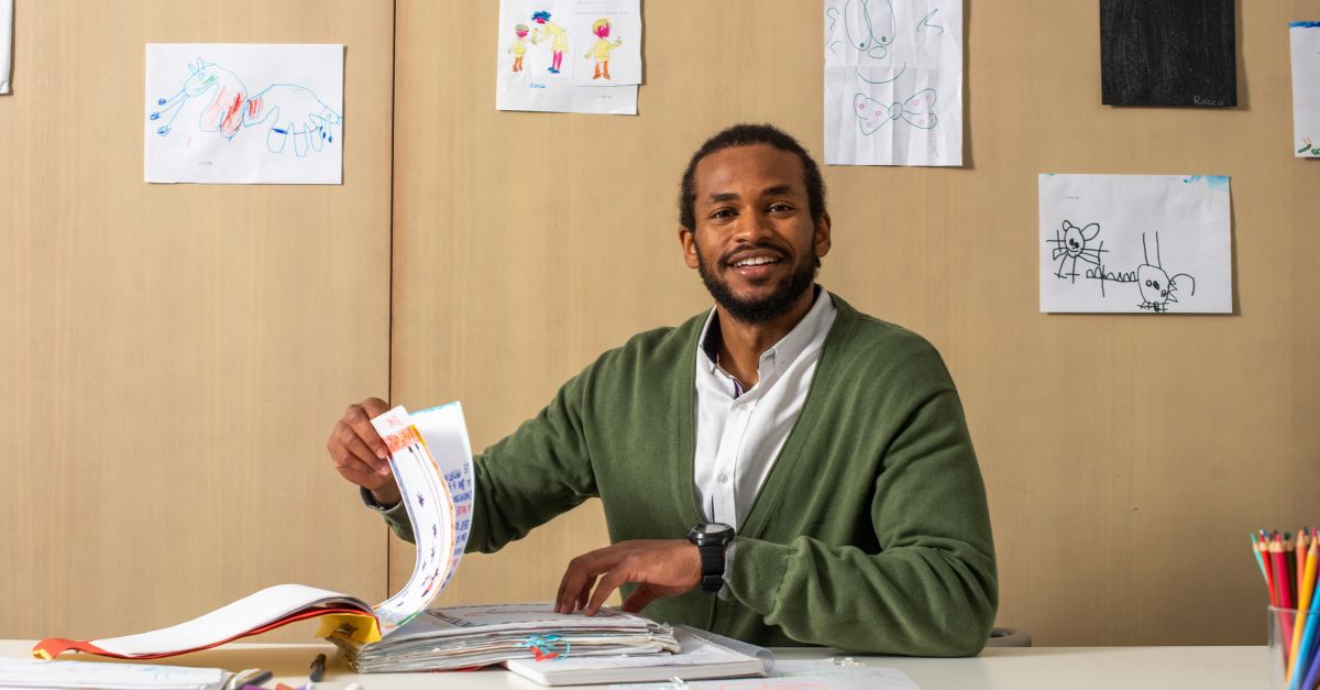 Early childhood educator reviewing notes and smiling at the camera