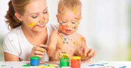 A teacher and infant with paint on their faces as they finger paint